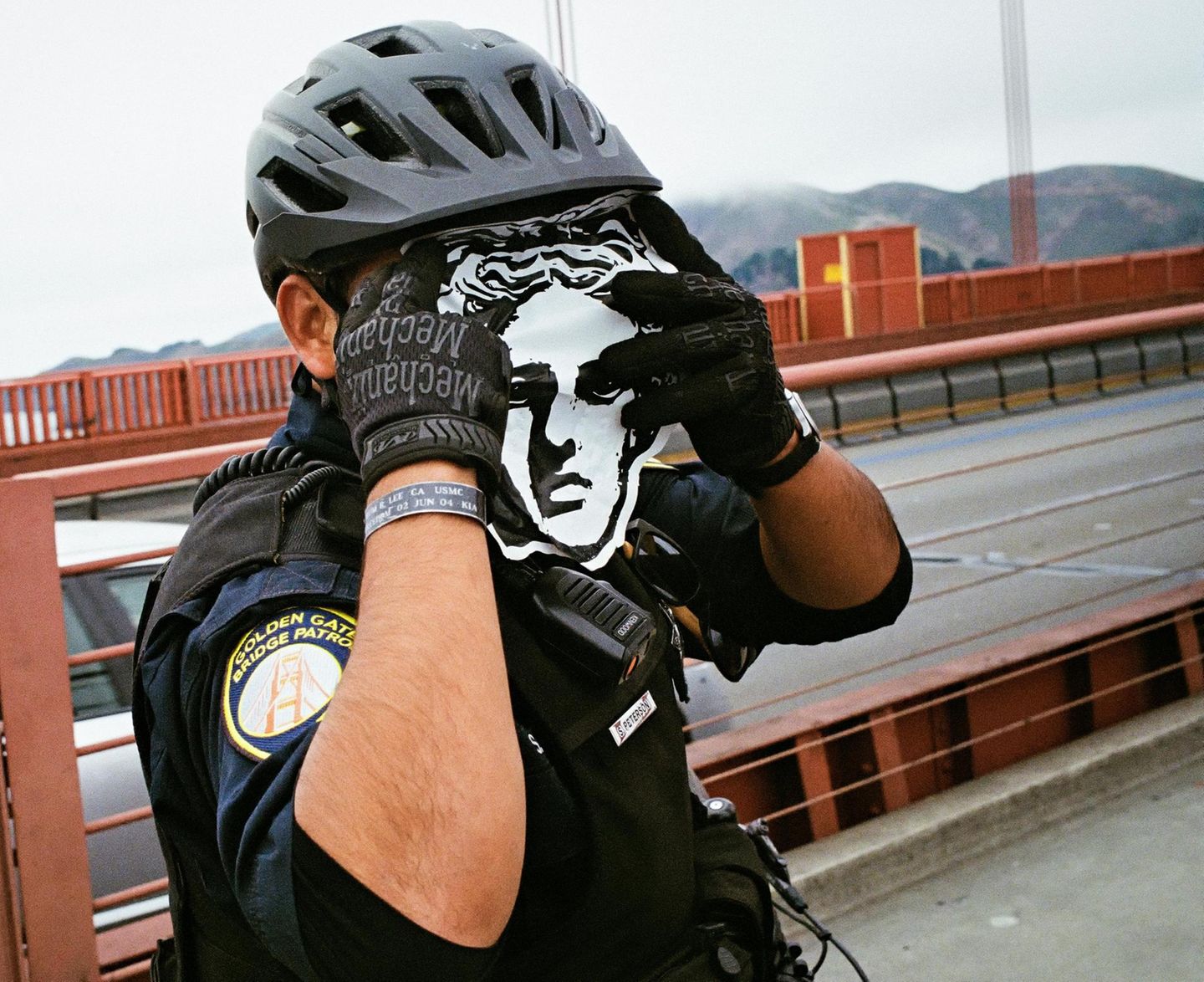 Ein Polizist der Golden Gate Bridge Patrol hält sich den Ausdruck des Gesichts der Venus von Milo vors Gesicht