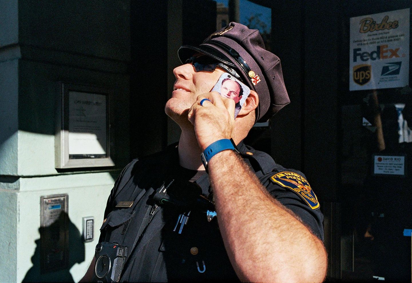 Ein Polizist blickt nach oben, während er mit seinem Smartphone telefoniert