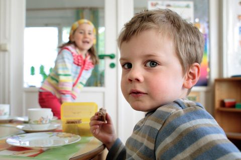 Ein Kind isst ein Brot. In England sollen Kinder Fleisch vom Reh essen
