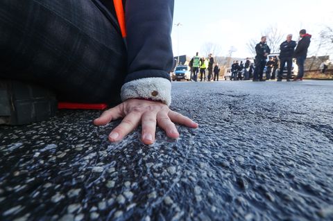 Ein Bild für die Archive: Ein Klimaaktivist hat sich mit Superkleber auf die Straße geklebt