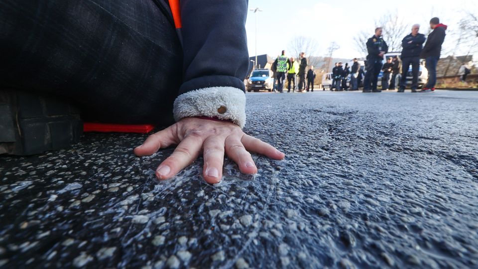 Ein Bild für die Archive: Ein Klimaaktivist hat sich mit Superkleber auf die Straße geklebt