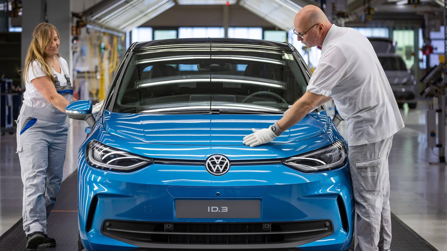 VW-Mitarbeiter bei der Qualitätskontrolle in einem Lichttunnel