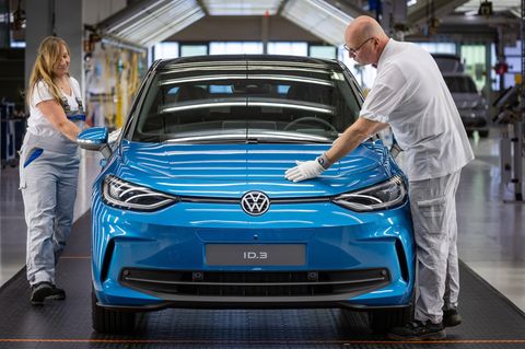 VW-Mitarbeiter bei der Qualitätskontrolle in einem Lichttunnel