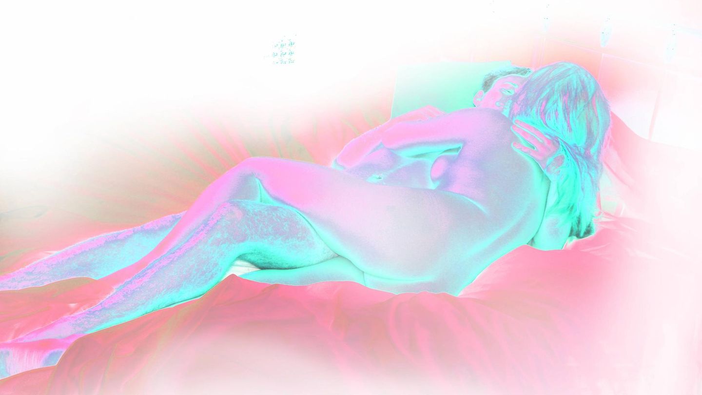 Sex im Schlaf: Ein Pärchen liegt im Bett und küsst sich Sex im Schlaf: Ein Pärchen liegt im Bett und küsst sich