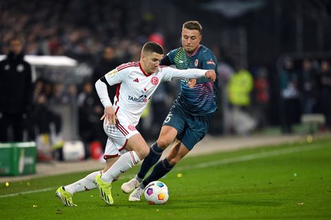 DFB-Pokal: Christos Tzolis von Fortuna Düsseldorf schiebt sich an St. Paulis Hauke Wahl vorbei