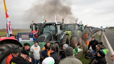 Landwirte kampieren mit ihren Traktoren an einer Autobahn