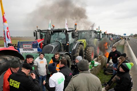 Landwirte kampieren mit ihren Traktoren an einer Autobahn
