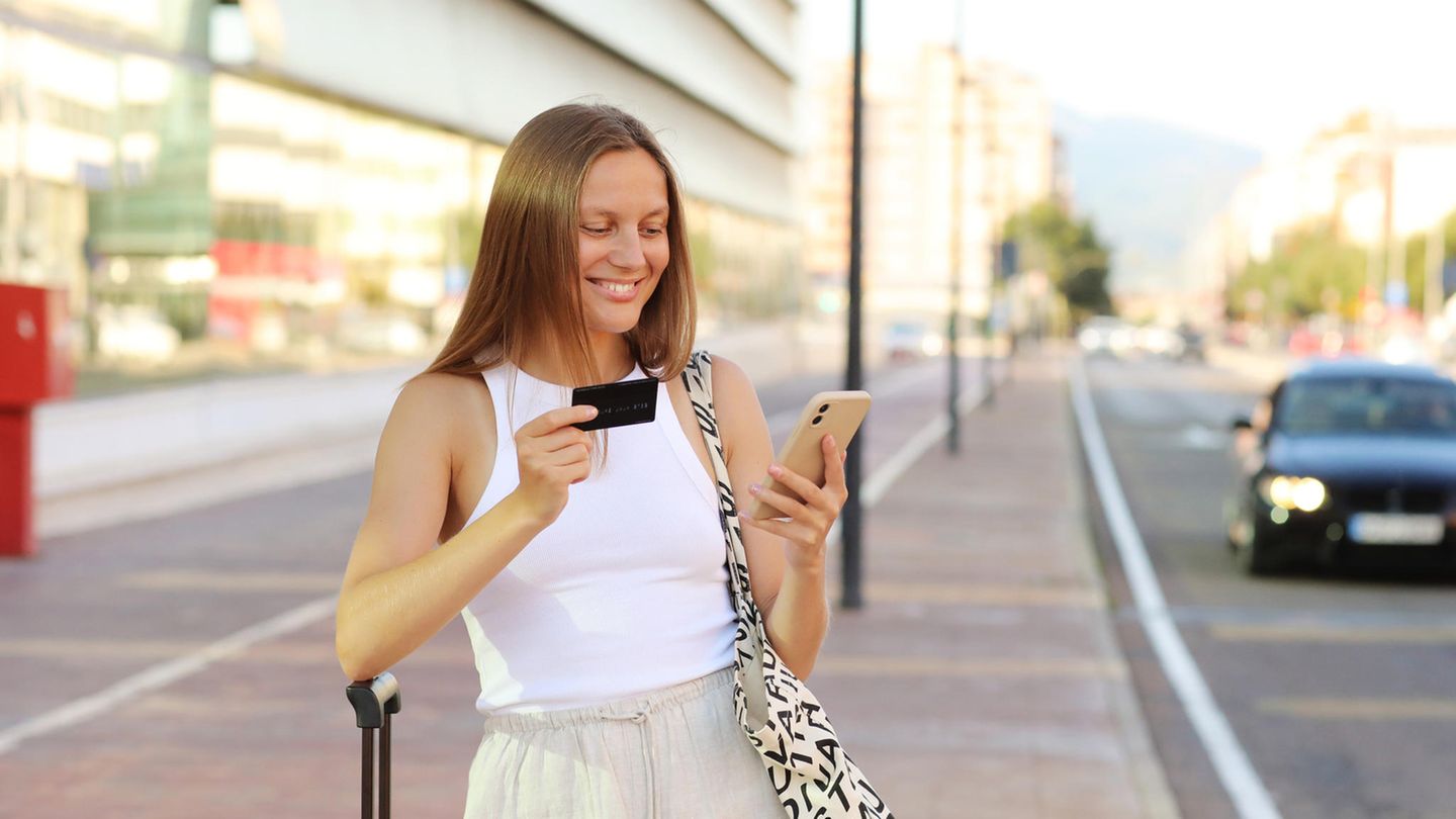 Junge Frau am Flughafen mit American Express Kreditkarte.