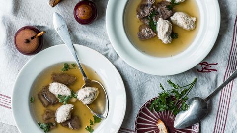 Brätknödelsuppe auf Tellern angerichtet und serviert