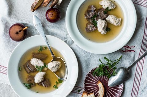 Brätknödelsuppe auf Tellern angerichtet und serviert