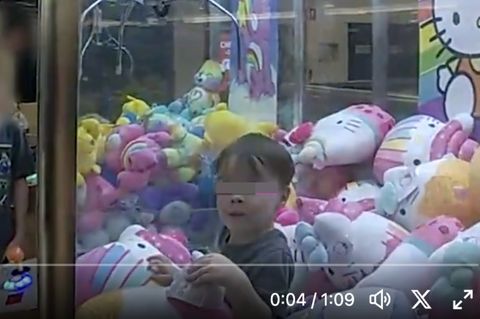Der dreijährige Ethan guckt aus dem Inneren des Spielautomaten heraus