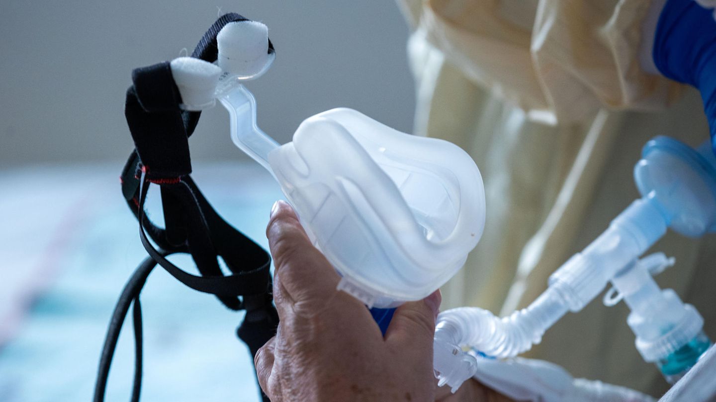 Krankheiten des Atmungssystems Die linke Hand eines älteren Menschen hält eine Maske zur Beatmung