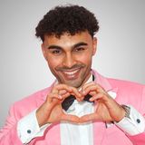 Portrait von Younes Zarou der seine Hände zu einem Herz formt