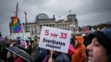 "Faschisten stoppen" steht auf einem Plakat, das ein Demonstrant in die Höhe hält.