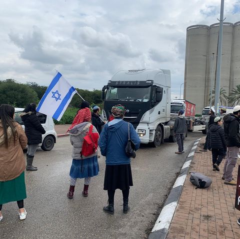 Menschen blockieren am Hafen der israelischen Stadt Ashdod Lastwagenlieferungen nach Gaza