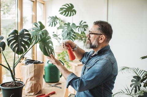 Ein Mann gießt seine Blumen