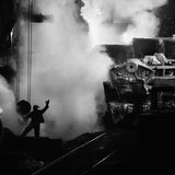 Ein Foto, das an avantgardistische Aufnahmen erinnert: Große Maschinen, kleiner Mensch. Ein Arbeiter in einem Stahlwerk
