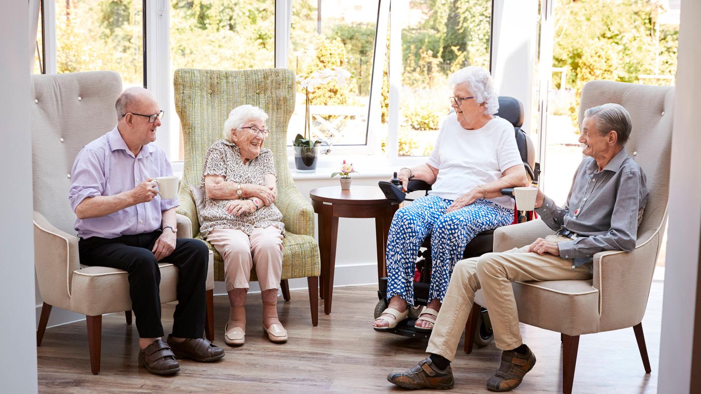 Senioren sitzen auf Sesseln und unterhalten sich