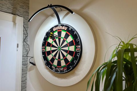 Dartscheibe ausleuchten: Dartboard mit Beleuchtung in einem Wohnzimmer