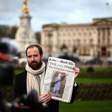 Das Schicksal des Königs hält die Nation in Atem: Ein Reporter berichtet die Lage vor dem Buckingham Palace in London. In seiner Hand hält er die Dienstagsausgabe der Times mit der Schlagzeile "Der König hat Krebs".