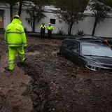Feuerwehrleute begutachten ein im Schlamm feststeckendes Auto in kalifornien