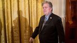 Steven Bannon, ein Mann im Anzug, vor einem goldenen Vorhang