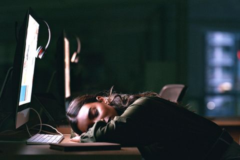 Eine Frau sitzt erschöpft vor dem Laptop.