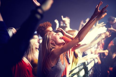 Eine Frau feiert bei einem Konzert.