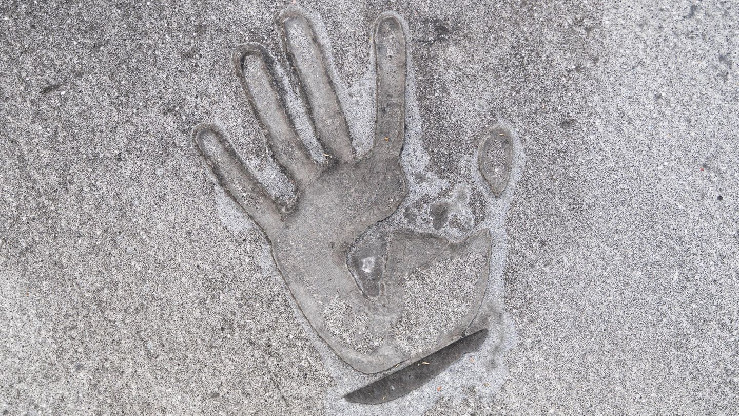 Handabdruck eines Klimaaktivisten, der sich mit Sekundenkleber auf die Straße geklebt hat