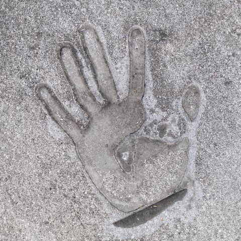 Handabdruck eines Klimaaktivisten, der sich mit Sekundenkleber auf die Straße geklebt hat Handabdruck eines Klimaaktivisten, der sich mit Sekundenkleber auf die Straße geklebt hat