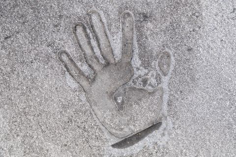 Handabdruck eines Klimaaktivisten, der sich mit Sekundenkleber auf die Straße geklebt hat