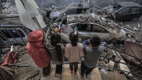 Kinder stehen vor den Trümmern zerstörter Häuser und Fahrzeuge nach einem israelischen Bombardement im Gazastreifen