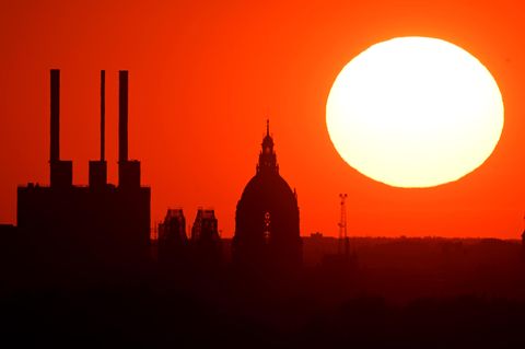 Die Sonne steht als roter Feuerball über die Skyline von Köln