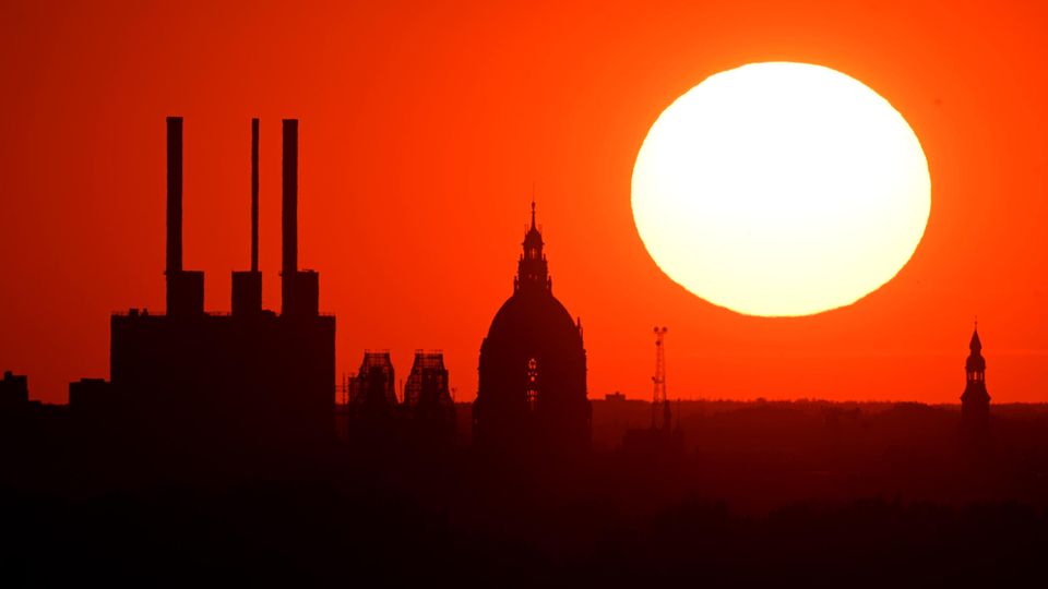 Die Sonne steht als roter Feuerball über die Skyline von Köln