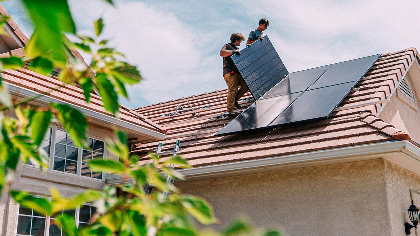Photovoltaik-Panele werden auf einem Hausdach installiert Photovoltaik-Panele werden auf einem Hausdach installiert