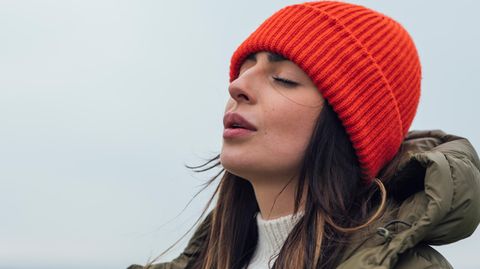 Stimmungsaufheller: Frau steht draußen und atmet ein