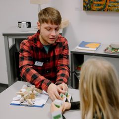 Therapeut Robin Zimmermann spielt Karten mit seinem Patienten