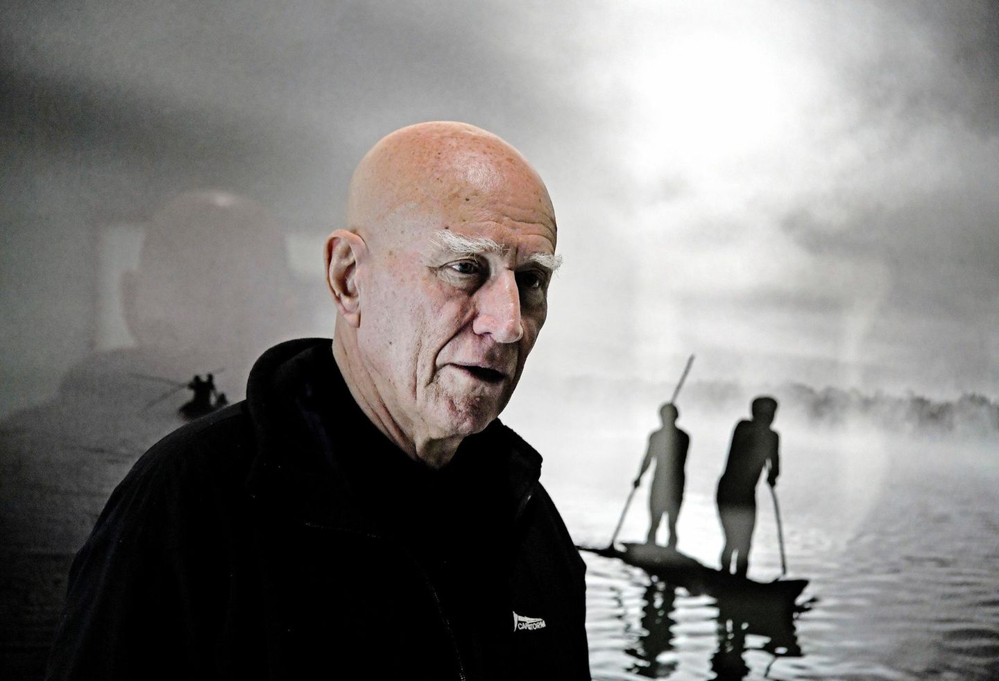 Portrait des Fotografen Sebastião Salgado vor einem seiner Werke