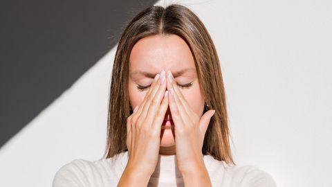 Trockene Nasenschleimhaut: Eine Frau fasst sich an die Nase