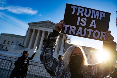 Trump als "Verräter": Eine Demonstrantin vor dem Supreme Court in Washington. Dort haben die Richter am Donnerstag begonnen, über einen möglichen Ausschluss des Ex-Präsidenten von den Wahlen zu entscheiden