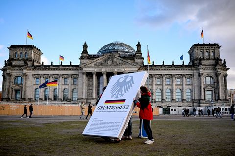 Aktivisten stellen einen Aufsteller mit dem Aufdruck "Grundgesetz" vor dem Reichstag auf