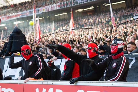 Fans des VfB Stuttgart werfen fröhlich Tennisbälle