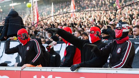 Fans des VfB Stuttgart werfen fröhlich Tennisbälle