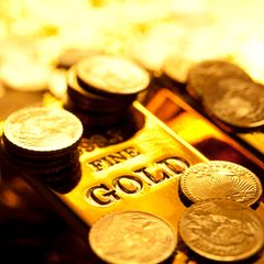 Ein Goldbarren und mehrere Goldmünzen