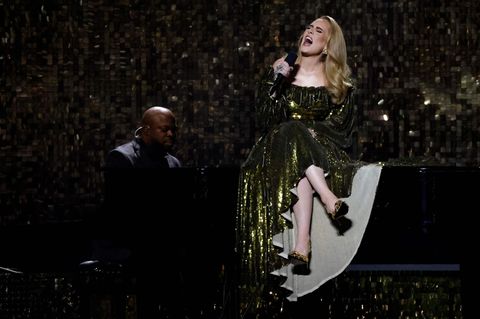 Adele sitzt bei einem Konzert auf einem Flügel.