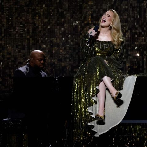 Adele sitzt bei einem Konzert auf einem Flügel.