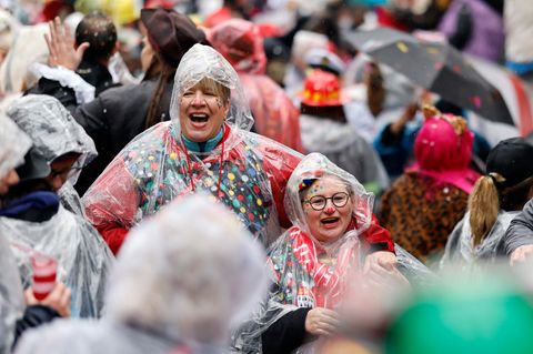 Wetter an Rosenmontag: Mit Regenhauben ausgestattete Karnevalistinnen