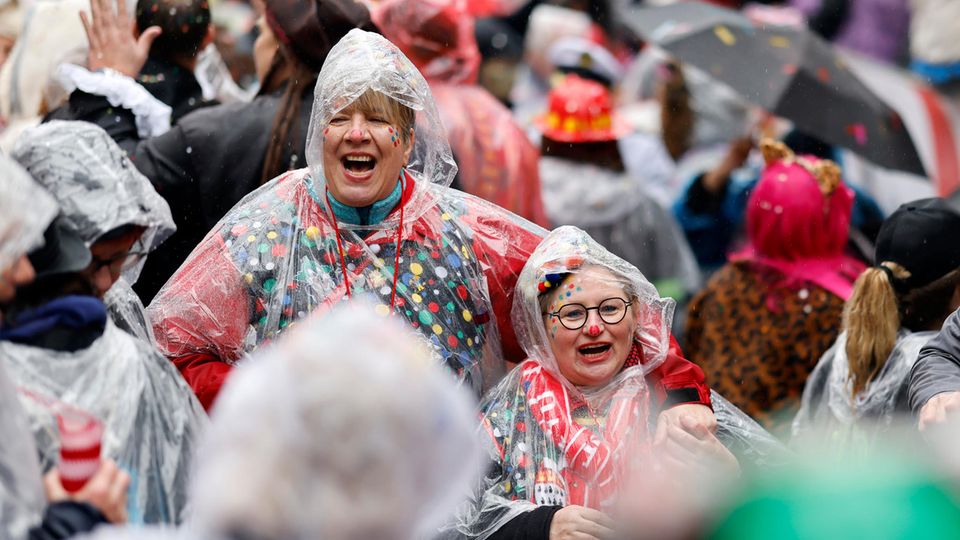Wetter an Rosenmontag: Mit Regenhauben ausgestattete Karnevalistinnen