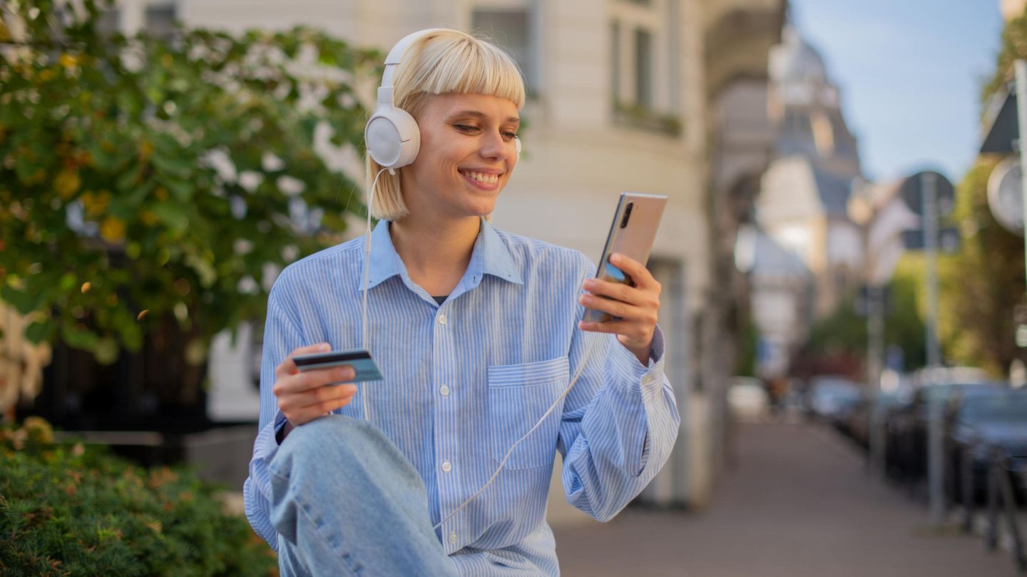Junge Frau mit Amex Kreditkarte beim Online-Shopping.
