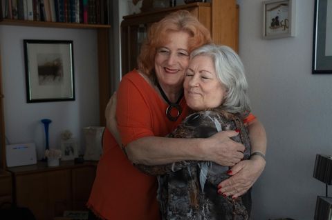 Ilse und Beate umarmen sich in ihrem Wohnzimmer